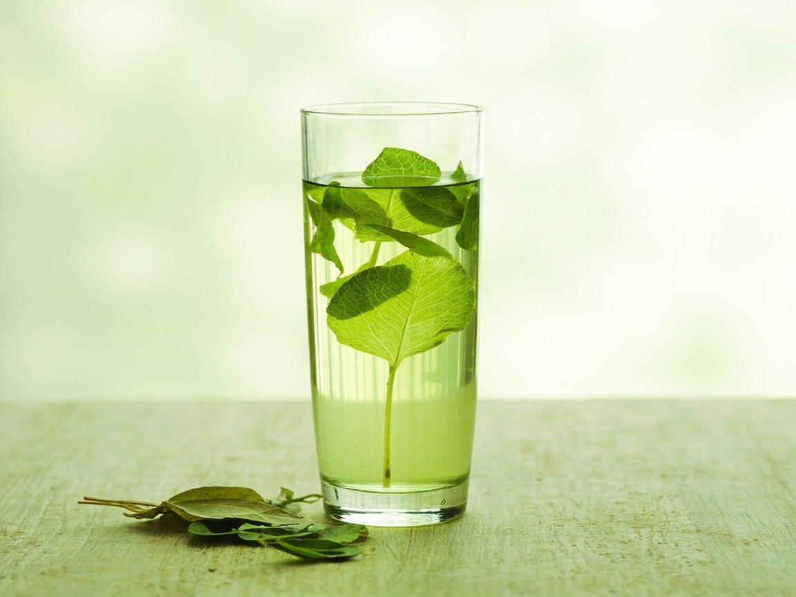 Longjing brewing in a tall glass tumbler